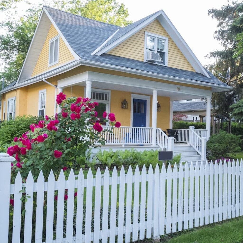 a yellow and white home with a picket fence in clark county kentucky