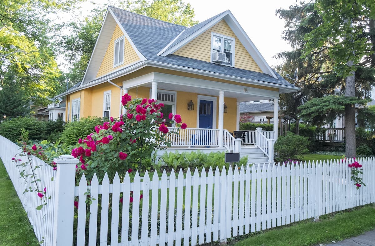 a yellow and white home with a picket fence in clark county kentucky